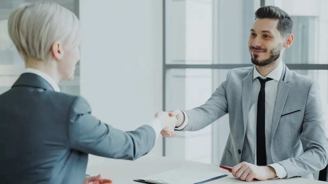 Two business people shaking hands over a loan agreement