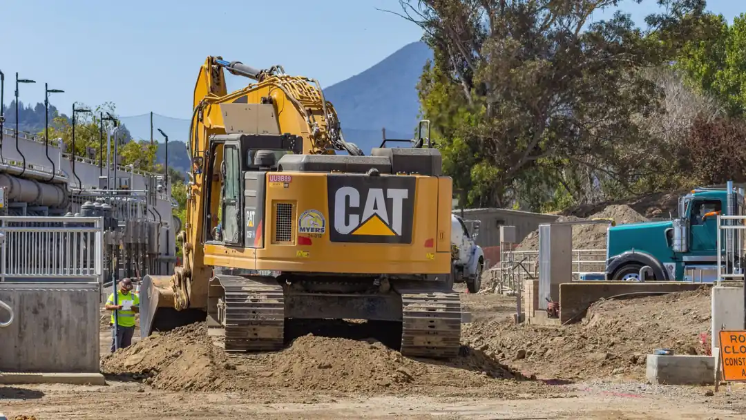 Yellow excavator and a truck working on a construction site